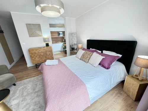 a bedroom with a large bed with a pink blanket at Hélios Plage in Berck-sur-Mer
