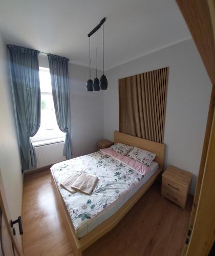 a small bedroom with a bed and a window at Apartament Willa Kilińskiego in Grudziądz