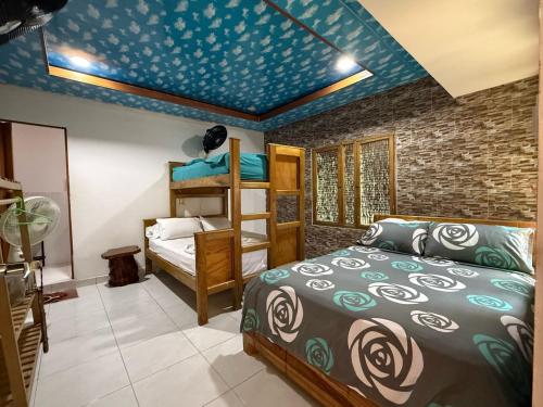 a bedroom with a bed and a blue ceiling at Isla Los Erizos EcoHouse in Isla Grande