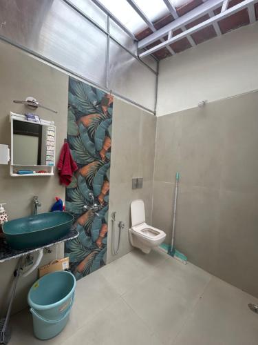 a bathroom with a sink and a toilet at Farmstay in Karjat along canal side in Mango orchard in Karjat