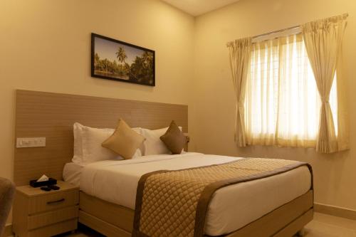 a bedroom with a large bed and a window at The Viva Grand in Chennai