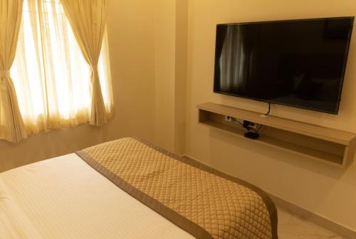 a bedroom with a flat screen tv and a bed at The Viva Grand in Chennai