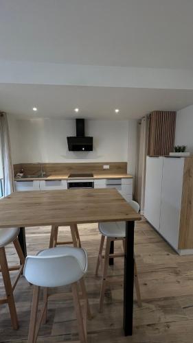 une cuisine avec une table en bois et quelques chaises dans l'établissement Studio plein centre ville, à Boulogne-sur-Mer