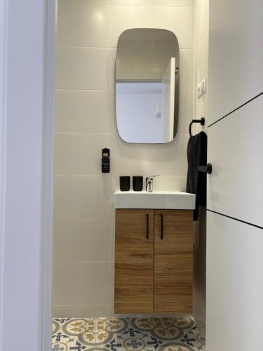 a small bathroom with a sink and a mirror at Casa Azul in Málaga