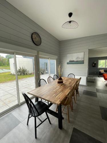 une salle à manger avec une table et des chaises en bois dans l'établissement Gîte Les Vents Salés - confort et détente dans la baie du Mt St Michel, à Roz-sur-Couesnon