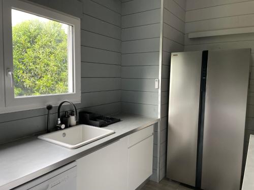 une cuisine avec un évier et un réfrigérateur dans l'établissement Gîte Les Vents Salés - confort et détente dans la baie du Mt St Michel, à Roz-sur-Couesnon