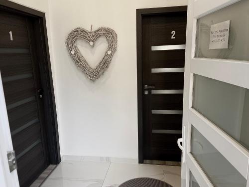 a heart hanging on a wall next to a door at Belvárosi Apartman in Miskolc