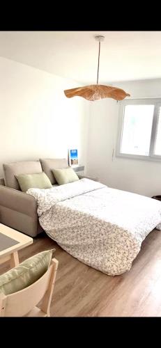 - une chambre blanche avec un lit et un canapé dans l'établissement L'Iris Provençal, Avignon France, à Avignon