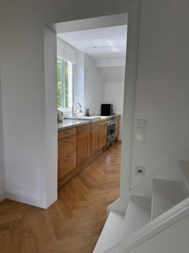 a kitchen with white walls and wooden floors at Charming Stadtvilla from 1895 Classic en Elegant in Kleve