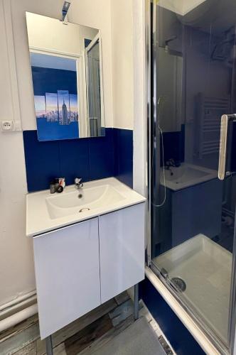 une salle de bain avec un lavabo blanc et une douche dans l'établissement Dalikyda - Manhattan - Free Parking, au Havre