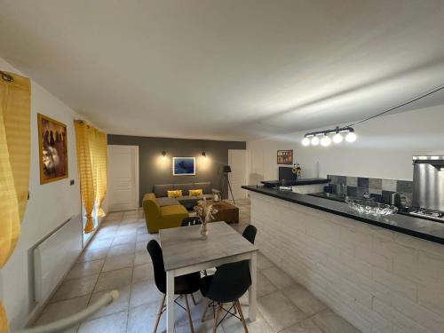 un salon avec une table et un canapé jaune dans l'établissement Grand appartement spacieux 3 ch Rez de villa a sisco, à Sisco