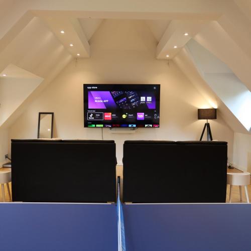 a room with two chairs and a tv on the wall at Chimneys Hot Tub Country Escape in Stourbridge