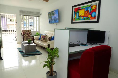sala de estar con escritorio y ordenador. en HABITACION SMART - baño semiprivado, en Cali