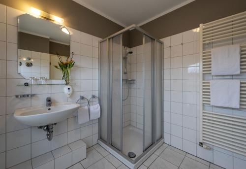a bathroom with a sink and a shower at Golfpark Ostsee Apartments in Ratekau