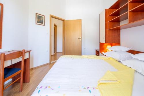 a bedroom with a large bed and a desk at Villa Alesa Steva in Tučepi