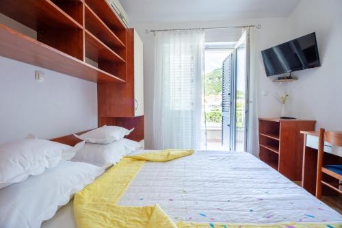 a bedroom with a bed and a tv and a window at Villa Alesa Steva in Tučepi