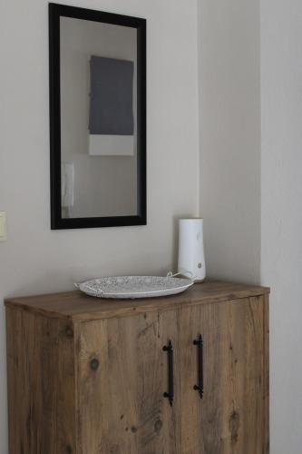 a mirror on top of a wooden cabinet in a room at Dream House 3 in Xanthi