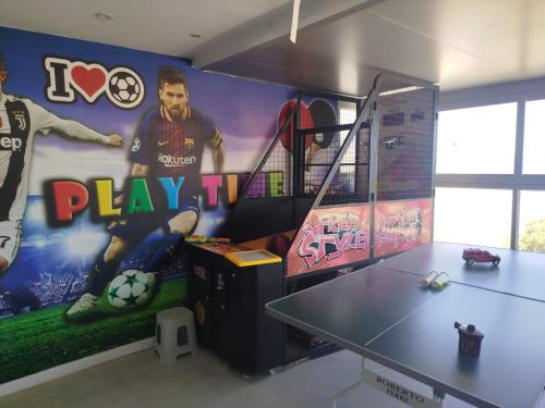 a room with a ping pong table and a mural at Vila first line to the sea in Netanya