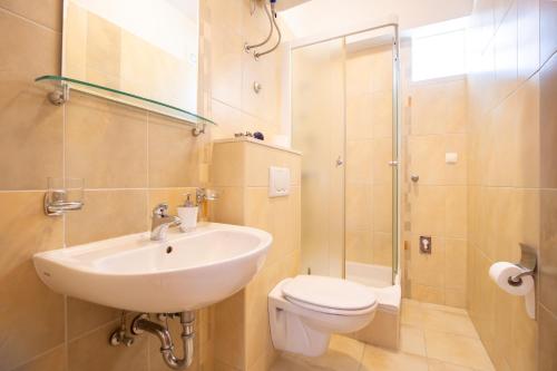 a bathroom with a sink and a toilet and a shower at Villa Alesa Steva in Tučepi