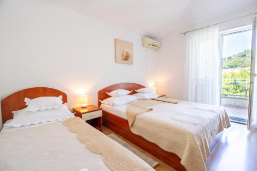 two beds in a room with a window at Villa Alesa Steva in Tučepi