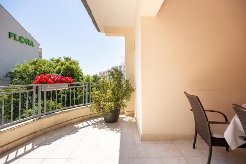a balcony with chairs and a plant on a building at Villa Alesa Steva in Tučepi