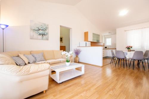 a living room with a white couch and a table at Villa Alesa Steva in Tučepi