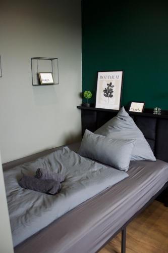 a bed in a room with a green wall at Apartment Deich 70 in Bremerhaven