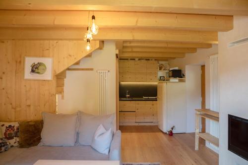 a living room with a couch and a kitchen at La casa nel Borgo - Cà Rezzuò 61 in Vodo Cadore