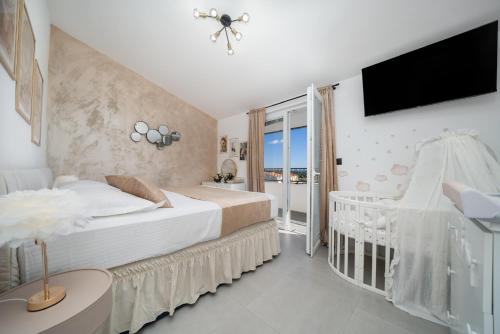 a bedroom with a bed and a tv and a crib at Luxury Dream House Nea with jacuzzi in Makarska