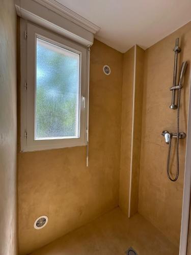 La salle de bains est pourvue d'une douche et d'une fenêtre. dans l'établissement Résidence KALLISTE, à Monticello