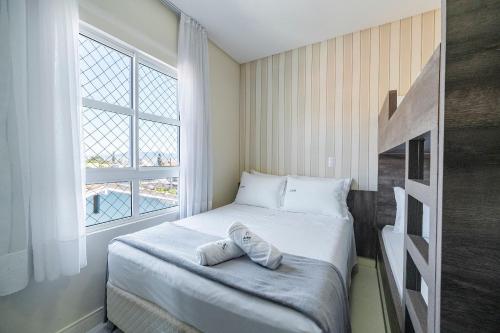 a bedroom with a bed and a window at Achei Itapema • Beira-mar e piscina em Porto Belo in Porto Belo
