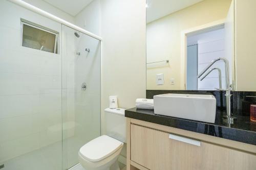 a bathroom with a toilet and a sink and a shower at Achei Itapema • Beira-mar e piscina em Porto Belo in Porto Belo