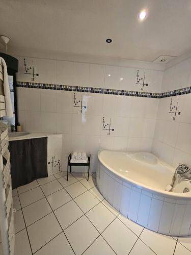 a white bathroom with a tub and a sink at Enjoy Garden in Vierzon