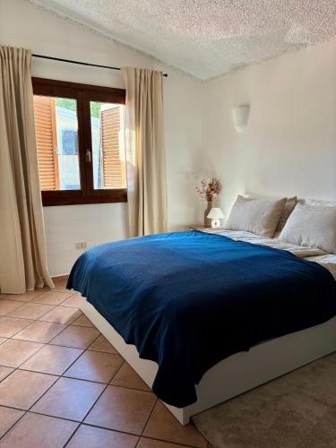 a bedroom with a large bed with a blue blanket at Appartamento Mare e Natura in Castelsardo