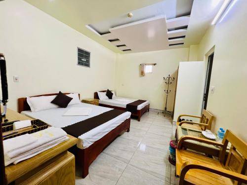 a hotel room with two beds and two chairs at Peaceful Mountain Hotel in Ha Giang