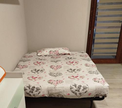 a small bedroom with a bed with a flowered bedspread at Casa Rossy in Pieve San Giacomo