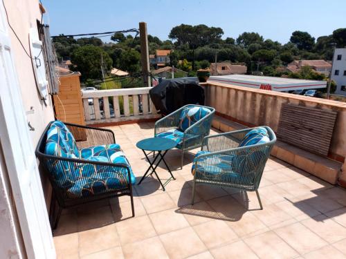 tres sillas y una mesa en un balcón en HAUT DE VILLA piscine 8 couchages, en La Ciotat
