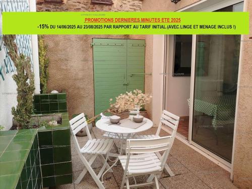 une table et des chaises sur une terrasse avec une porte verte dans l'établissement 6EGA14 Superbe maison Familiale 6 personnes, à Collioure