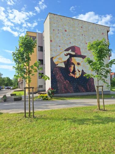 a large painting of a man in a hat on a building at STUDIO APARTMAN MARKo C self-check in,frre parking in Karlovac