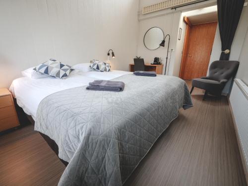 a hotel room with a bed and a chair at Hótel Skálholt in Golden Circle in Skálholt