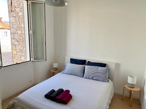 une chambre avec un lit blanc avec deux serviettes dessus dans l'établissement Charming apartment in the heart of Cannes, à Cannes