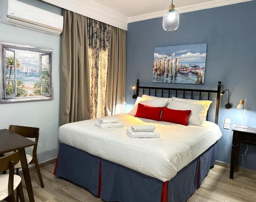a bedroom with a bed with red pillows and a desk at Colorsphere in Thessaloniki