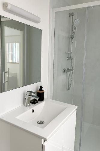 une salle de bain blanche avec un lavabo et une douche dans l'établissement Studio Cosy - Doutre Centre Angers, à Angers
