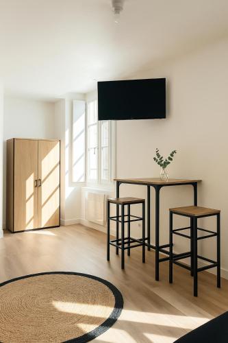 - un salon avec une table et deux tabourets dans l'établissement Studio Cosy - Doutre Centre Angers, à Angers