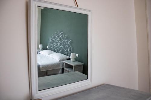 a mirror in a room with a bed and a bed sqor at B&B San Savino in Piacenza