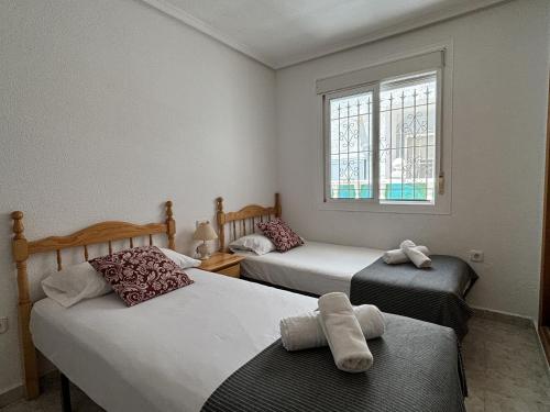 a bedroom with two beds and a window at Casa Limonero by Rental Hero in Los Alcázares