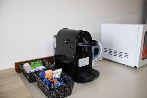 a black coffee maker sitting on a counter next to a microwave at B&B San Savino in Piacenza