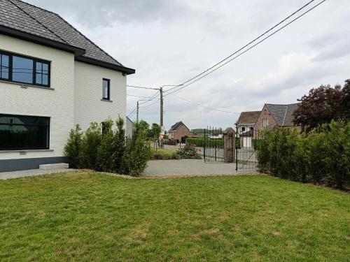 a white house with a yard with grass at Vakantiehuis 't Ketsken - Gavere in Gavere