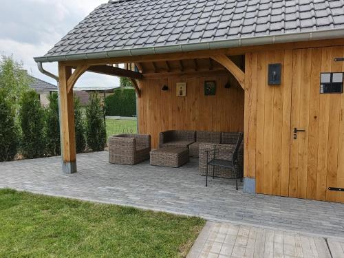 a pavilion with a couch and chairs on a patio at Vakantiehuis 't Ketsken - Gavere in Gavere