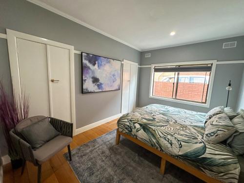 a bedroom with a bed and a chair and a window at Big home perfect for the whole group in Morwell